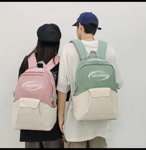 Detail view of stylish dual-tone casual school backpacks worn by models for daily use.