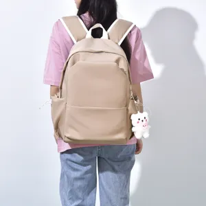 Mochila escolar de gran capacidad de color sólido con bonito colgante de oso para uso diario.