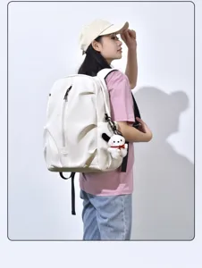 Detail shot of a white casual backpack with cute puppy keychain and spacious storage pockets.
