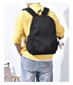 Details of the black casual backpack, showing back view and cute plush pendant decoration.