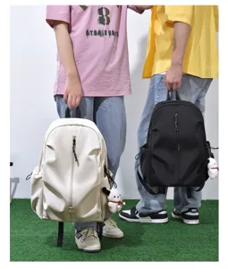 Detail view of large capacity casual couple backpack, solid color with cute plush pendant.