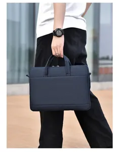 Nahaufnahme einer eleganten dunkelblauen Laptoptasche in der Hand, moderner Business-Stil.
