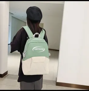 Casual green and white student backpack detail view, featuring spacious main compartment.