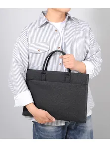 Vista dettagliata di una borsa ventiquattrore per laptop da lavoro grigio scuro minimalista.