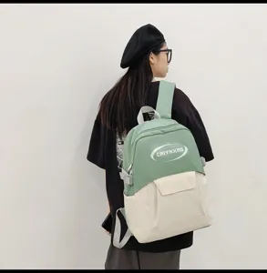 Detailed view of the stylish two-tone canvas backpack with front pocket and adjustable straps.