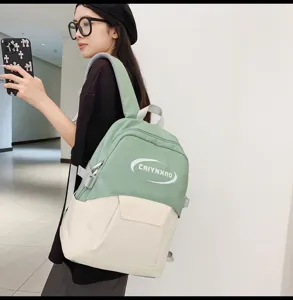 Detailed view of the stylish green and white casual backpack worn by model, showcasing front pocket.