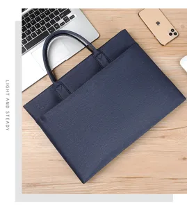 Vista di dettaglio dell'elegante borsa per laptop che mostra trama e manici sulla scrivania.
