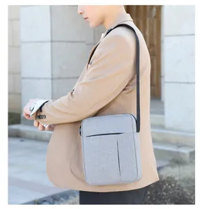 Detailed view of the light grey nylon crossbody shoulder bag worn by male model outdoors.