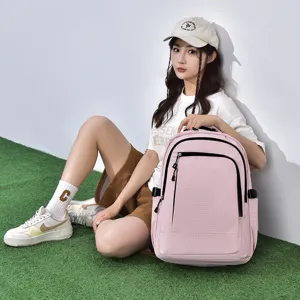 Pink grid backpack detail view showing durable fabric, black zipper pockets, and large capacity.