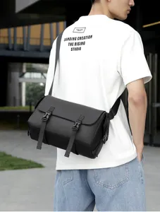 Detalle de vista del bolso bandolera negro para hombre con tela duradera y hebillas.