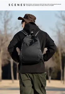 Detail view of lightweight folding waterproof travel backpack worn by model outdoors.