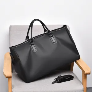 Detail view of the black duffel gym bag showing its spacious interior, sturdy handles and zipper.