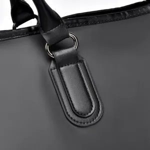 Close-up detail of black PU leather gym bag handle, metal connecting ring and fine stitching.