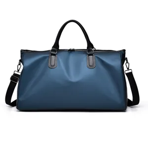 Detailed view of the dark blue travel duffel bag, showing waterproof fabric and sturdy handles.