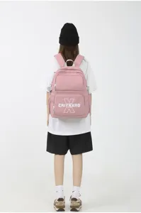 Roze college stijl canvas rugzak met handig voorvak en witte grafische print details.