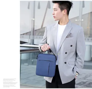 Detailed close-up view of the stylish blue nylon crossbody bag held by a model in a smart blazer.
