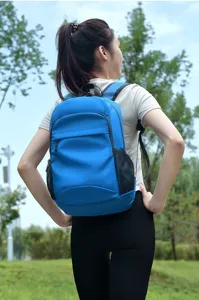 Outdoor blue foldable backpack detail view showing comfort wear on model in green park setting.
