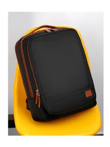 Detailed view of the black backpack showcasing the durable fabric and brown leather accents.