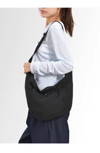 Detail view of black soft slouchy crescent shoulder bag worn by model, casual lightweight design.