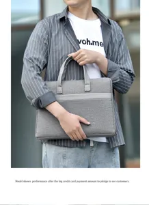 Nahaufnahme einer professionellen grauen Laptoptasche, gehalten von einem Model im Businesslook.