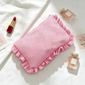 Closeup view of pink white striped seersucker cosmetic bag featuring cute ruffle edge details.