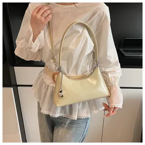 Retro shoulder armpit bag detail, pale yellow glossy leather, chic chain accent, daily wear.