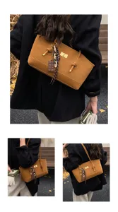 Detail shot of brown suede tote bag featuring a chic chocolate charm and gold twist lock closure.