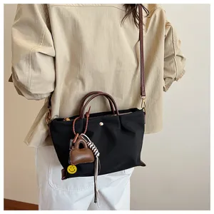 Simple versatile black handbag with brown handles, casual lightweight crossbody bag for women.