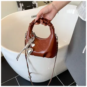 Braune plissierte Damen Handtasche mit stilvollem Kettenriemen und Metall Anhängern.