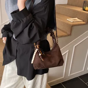 Vintage suede pleated shoulder bag for women, retro brown top-handle dumpling purse.