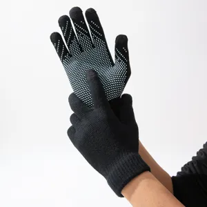 Vue détaillée de gants tactiles en tricot noir avec des points antidérapants bleus.