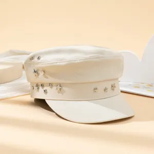 Casquette plate beige style militaire avec rivets etoiles metalliques, detail retro.