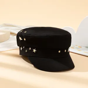 Gros plan détaillé de la casquette gavroche noire avec des clous d'étoiles métalliques.
