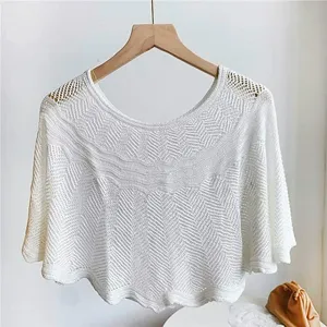 Detailed view of the white knitted hollow-out shawl, showcasing delicate crochet pattern.