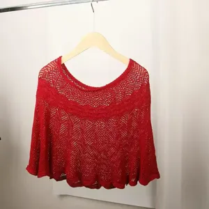 Red knitted hollow shawl detail, stylish summer air-conditioning cape, elegant lightweight cover-up.