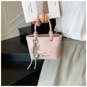 Chic pink textured bucket handbag for women featuring stylish silver charms and knots.