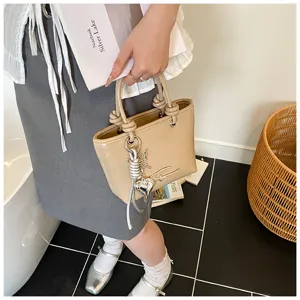 Textured retro patent leather handbag for women, chic top handle tote bag with metal charm.