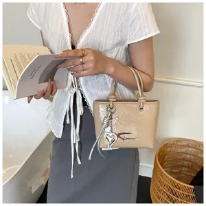 Retro glossy handbag for women, vintage style small tote bag with metal charm and handle.