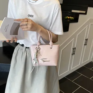 Pink crinkled patent leather handbag for women, vintage style top handle bucket bag with chic pendant.