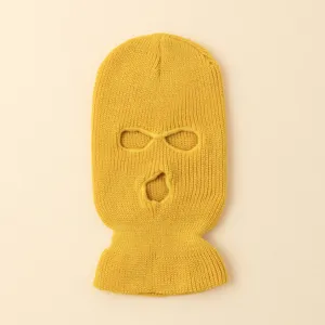 Primer plano de pasamontañas de punto amarillo con tres agujeros, detalle de invierno.