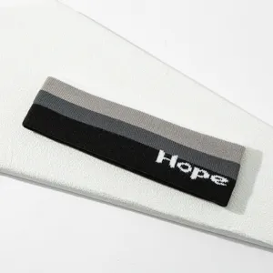 Cinta deportiva de punto con rayas tricolores y diseno Hope para entrenamientos.