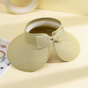 Détail rapproché de la visière de soleil en paille pliable pour femme avec élégant nœud chic.