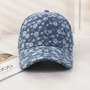 Vue détaillée d'une casquette de baseball en jean bleu avec motif floral clair partout.