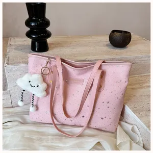 Close-up detail of the pink star-printed tote bag featuring a cute cloud plush pendant.
