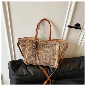 Geweven strooien shopper voor dames, stijlvolle strandtas met bruine lederen handvatten.