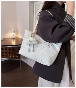 Detailed view of the white star-printed tote bag with cute cloud pendant, stylish and roomy.