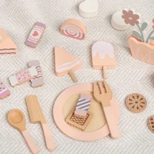 Wooden pretend play dessert toy set with pastel cake, cookies, plate and cutlery, top view.