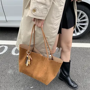 Brown suede shoulder tote bag for women, large capacity commuter casual handbag with charm.