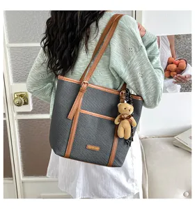 Stylish casual tote shoulder bag for women, large capacity textured design with bear pendant.