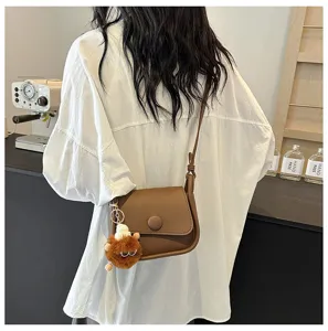 Brown leather crossbody bag for women, stylish small square shoulder bag with plush keychain.